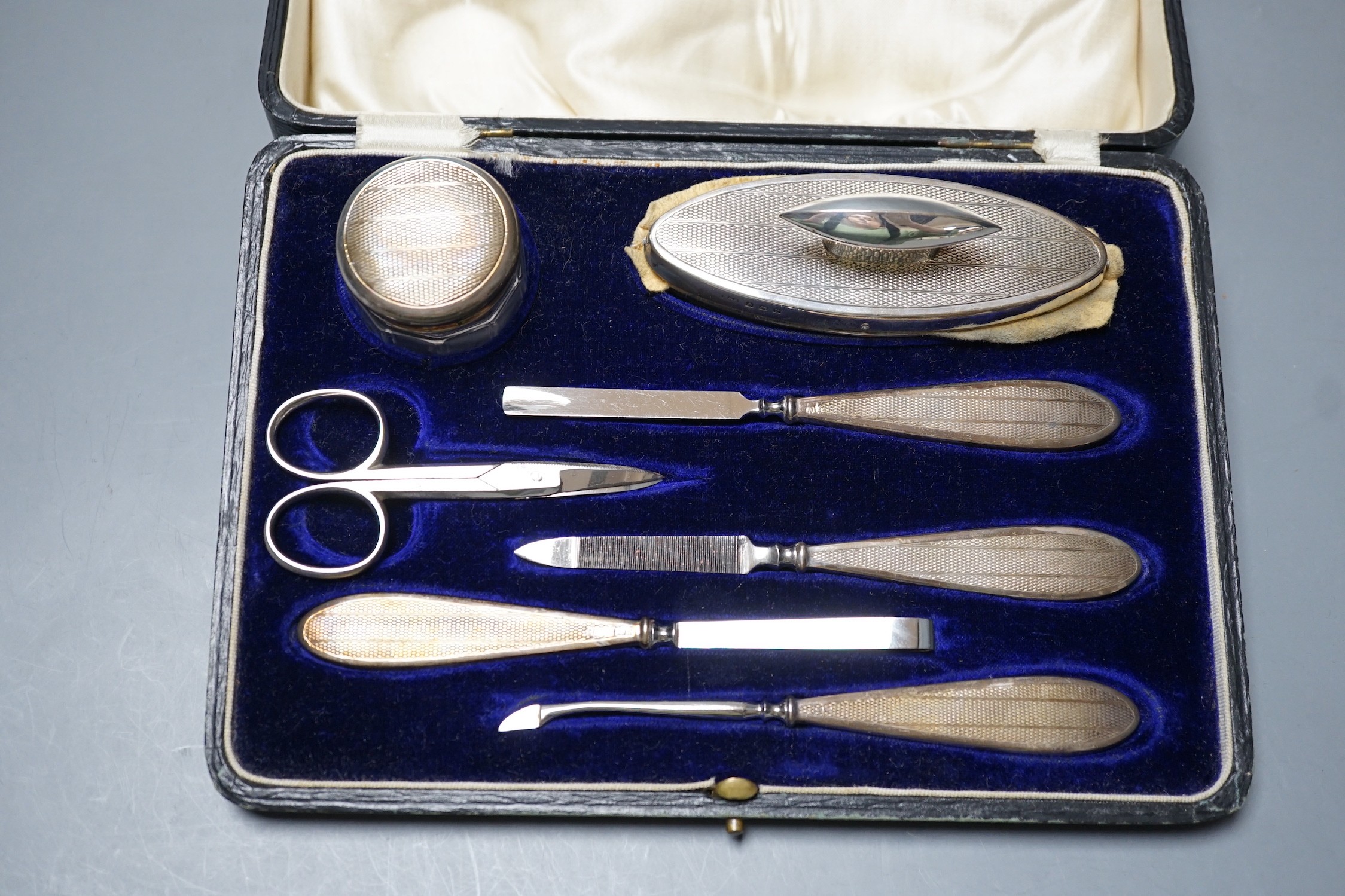 A cased George V silver mounted seven piece manicure set, Birmingham, 1923.
